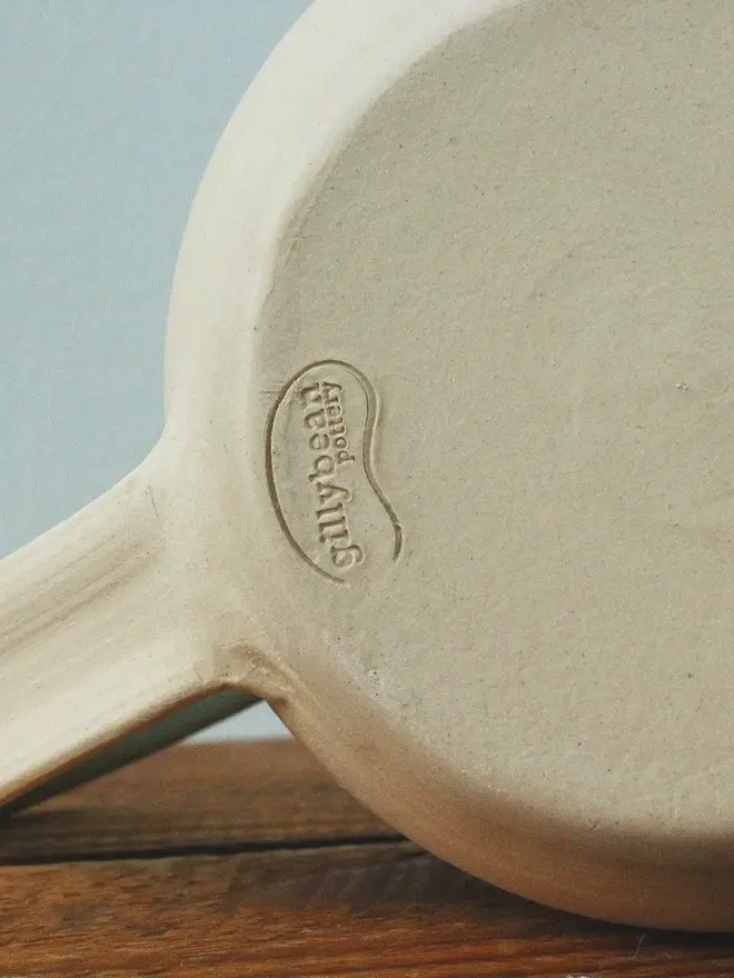 Close-up view of the bottom of a green ceramic mug.