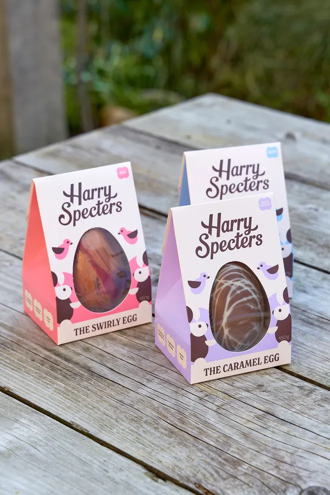 Bundle of three branded eggs on a wooden table in an outdoor garden setting