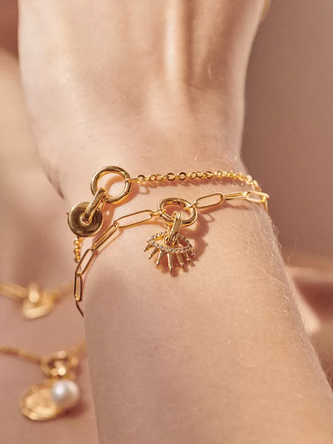 woman wearing gold bracelets with charms