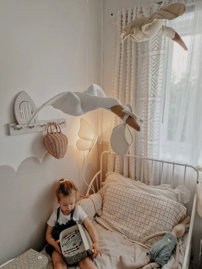 Flying Stork Hanging Decoration, a hanging stork decoration suspended in a child's bedroom. 