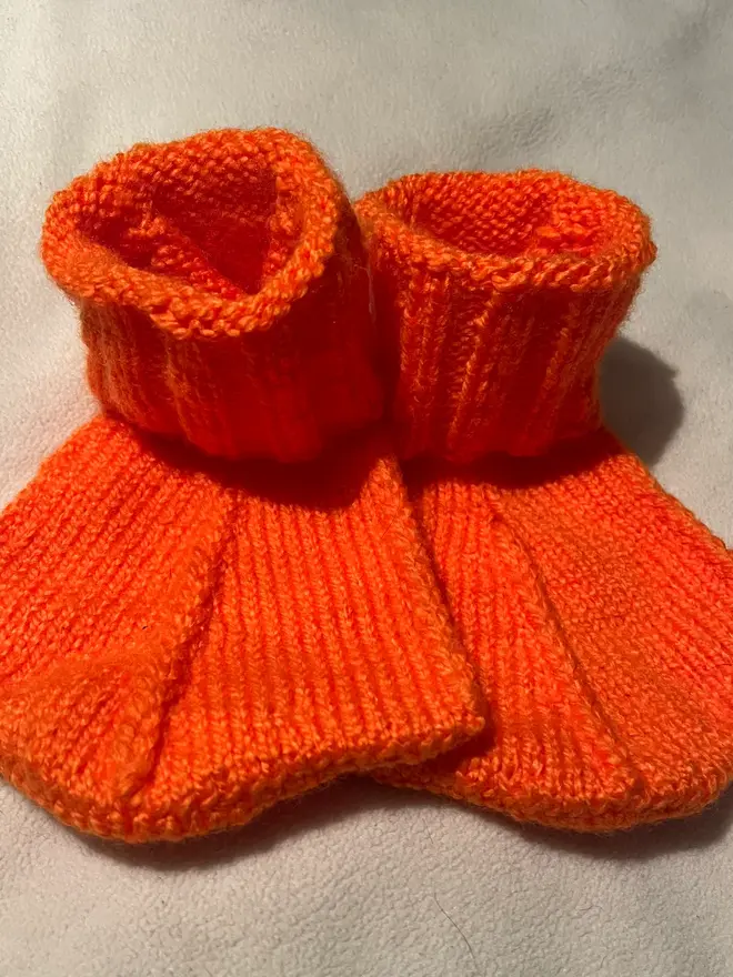 Duck Feet Socks, a pair of orange duck feet socks sitting on a plain surface. 