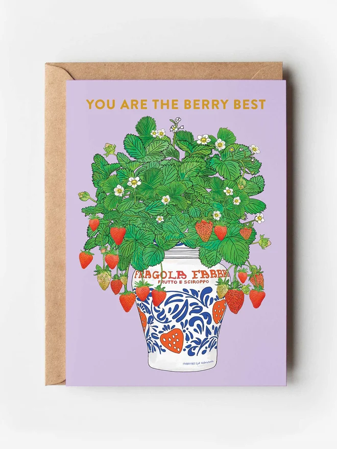 Food-inspired illustrated greeting card featuring a colourful strawberry plant bouquet in a white iconic Italian Fragola marmalade jar, set against a bold lilac purple background. A charming and vibrant design perfect for fruit lovers and anyone who appreciates quirky, food-themed artwork.