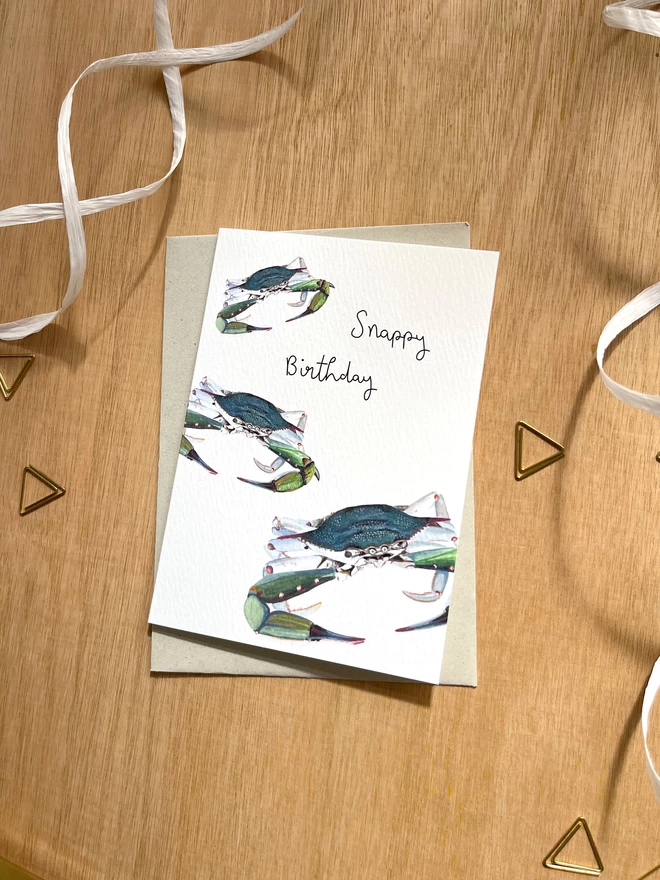 a greetings card featuring three blue crabs with the phrase “snappy birthday”