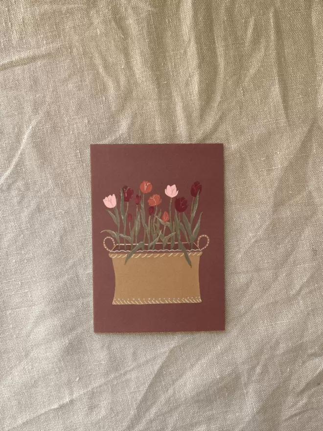 tulips growing in a decorative tub on a greetings card 