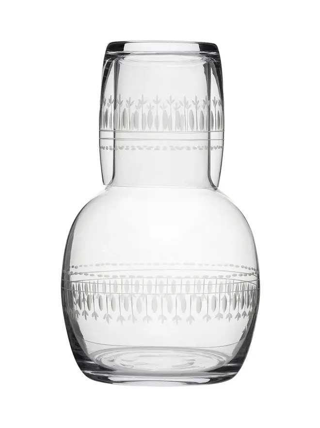 engraved ovals crystal carafe set. a glass carafe and matching glass with a delicate oval pattern.