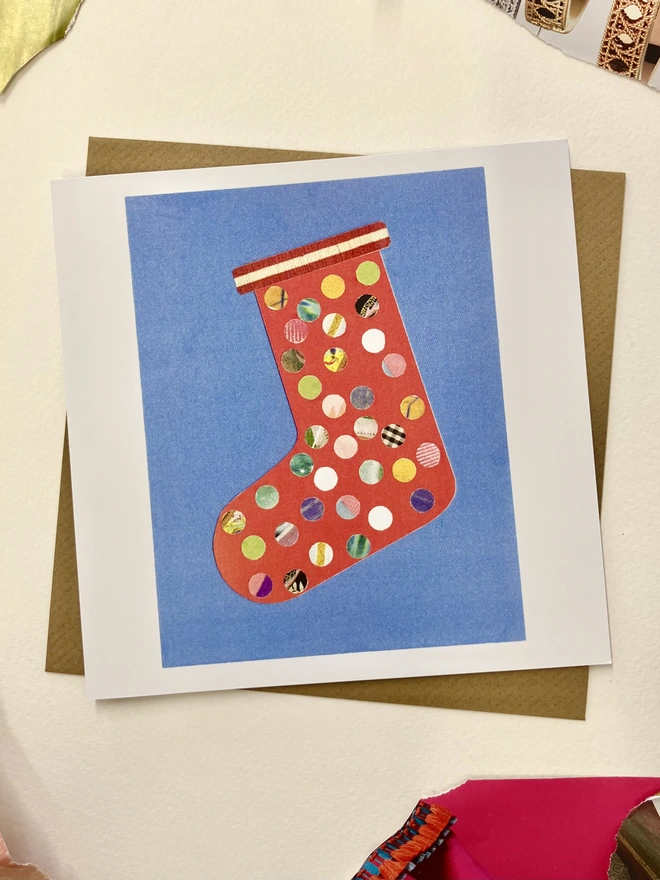 Christmas card featuring a sprinkle illustrations of a stocking on a white background with collage papers