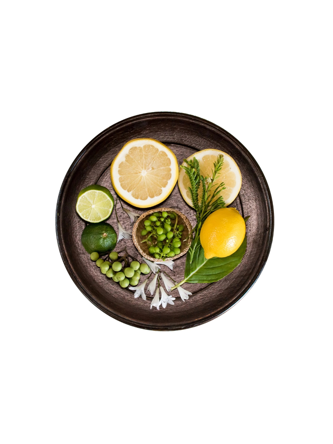 mandarin and sicilian bergamot natural wax candle. a round tray holding natural ingredients.