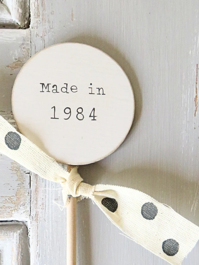 wooden circle shaped cake topper with hand painted message and custom ribbon