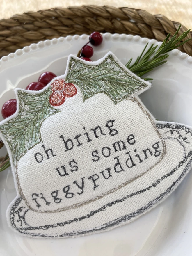 Figgy Pudding Embroidered Fabric Decoration on a plate with berries