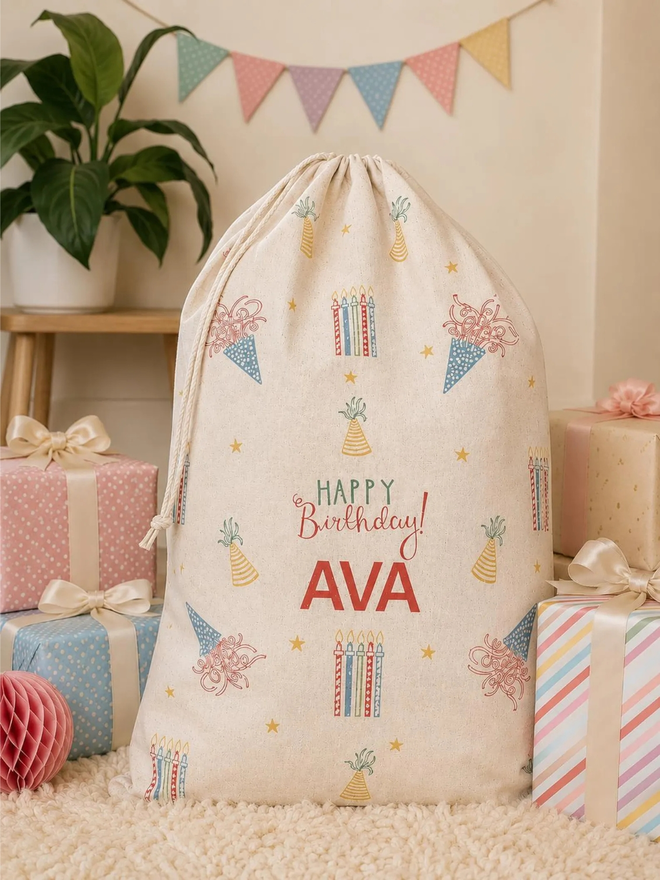 personalised drawstring birthday bag. a drawstring bag with printed candles, streamers and a birthday message.