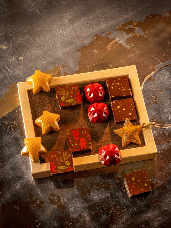 Christmas chocolate box containing 4 kinds of colourful bonbons - including yellow stars, gingerbread