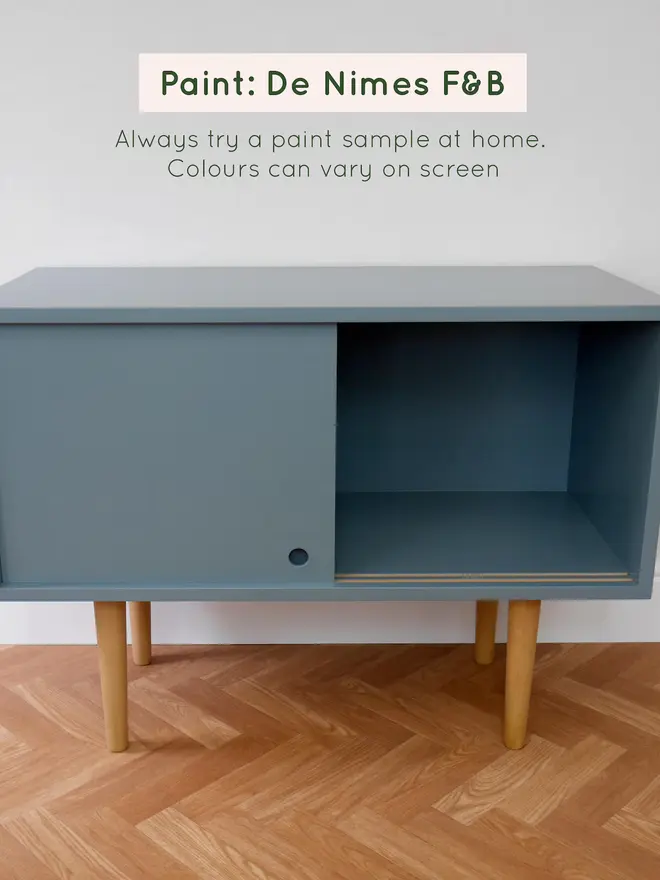 Teal mid-century cabinet in a styled living room with wooden legs.
