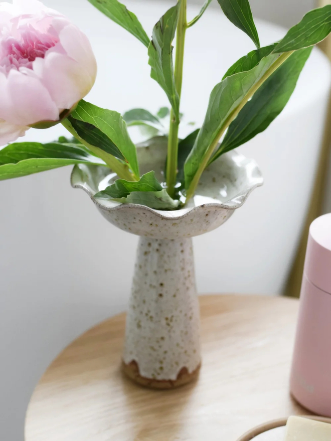 Wavy pedestal vase. A stoneware speckled hand thrown pedestal vase on a bedside table