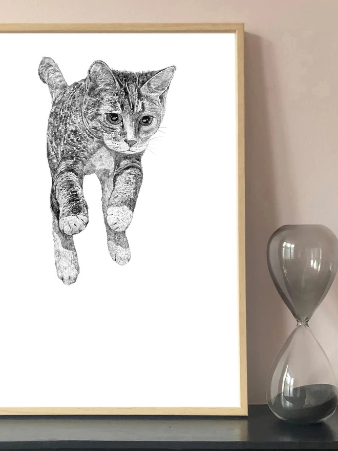 Art print of a hand drawn illustration of a cat jumping up displayed in a frame