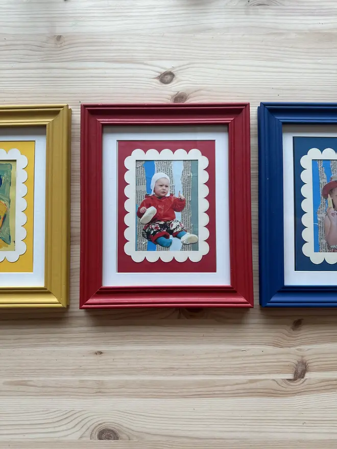 Scallop Edged A5 / A4 photo mount. red yellow and blue options placed in frames on wooden surface.