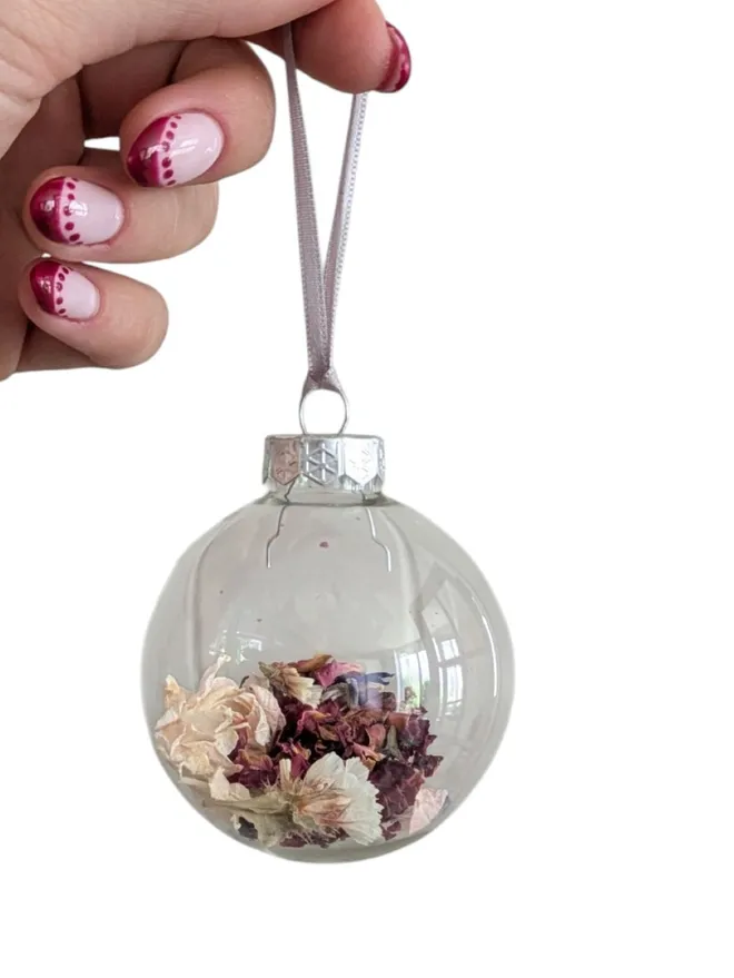 burgundy and ivory flower petals in glass bauble