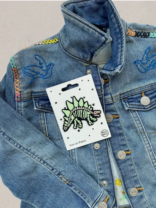 Glow in the dark dinosaur patch on embroidered kids denim jacket.