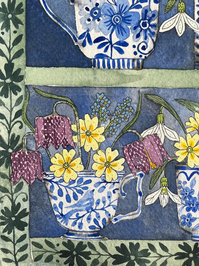 daffodils, snowdrops and spring flowers in delftware teacups displayed in a plant theatre