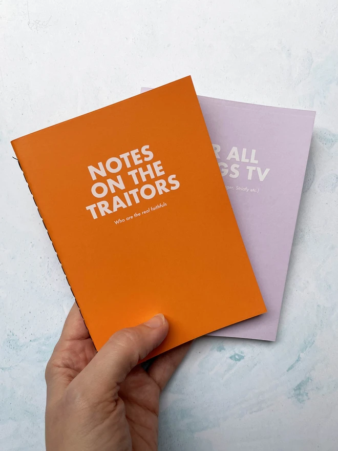 personalised notebook in orange saying "notes on the traitors"