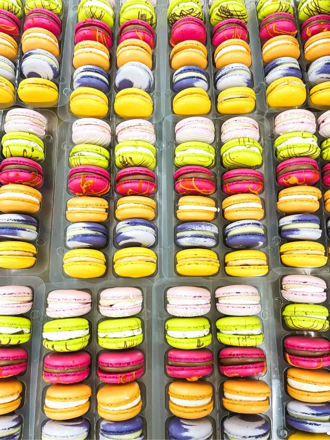 many colourful autumn macarons are arranged in a tray