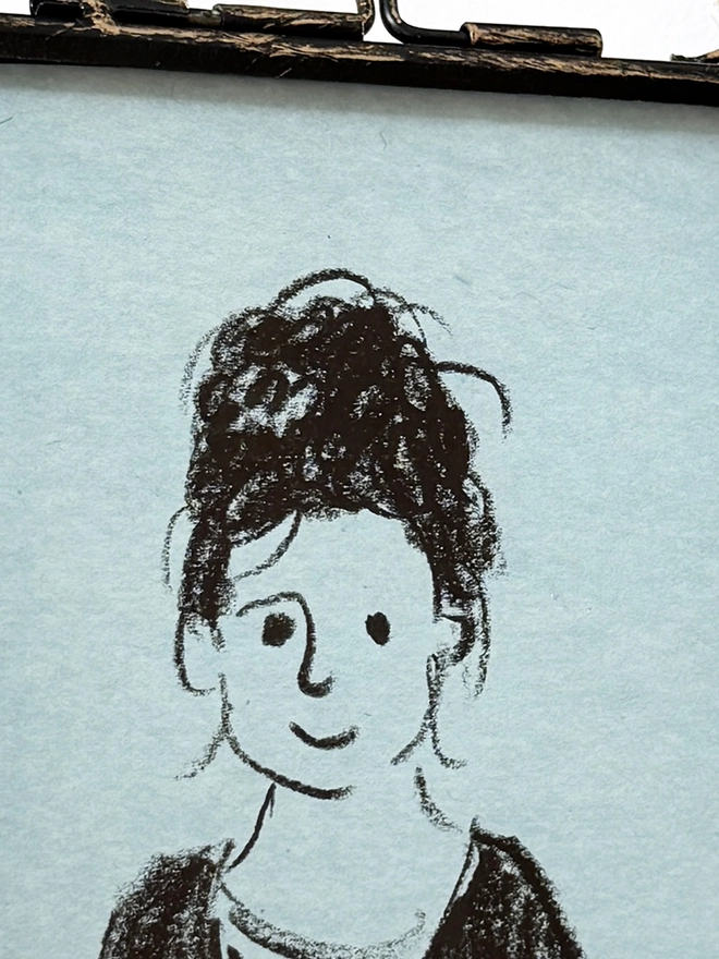 sketchy portrait on blue paper in metal frame