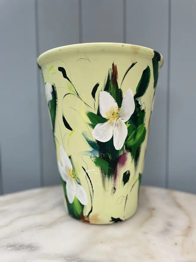 Hand-painted terracotta plant pot featuring white clematis flowers on a pale green background  