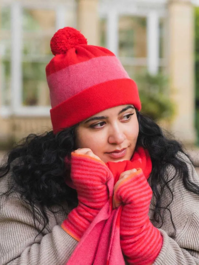 merino wool red pink beanie hat worn on model with matching accessories