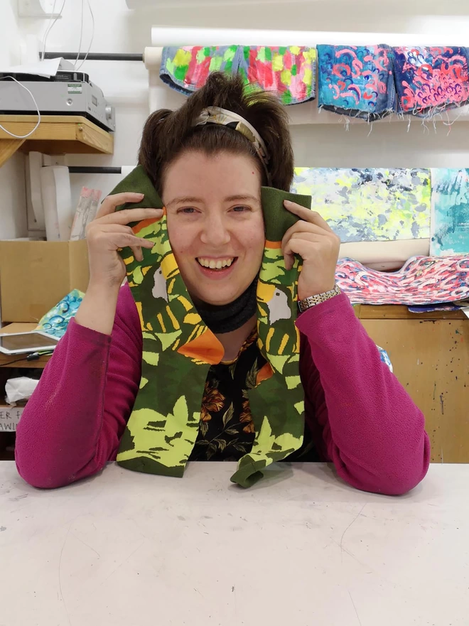 Happy artist holding amazon 100% organic charity cotton socks in green & yellow