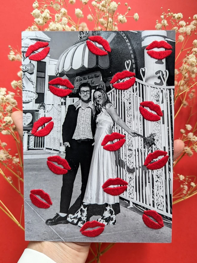 Couples photo with red embroidered lips, held over red background