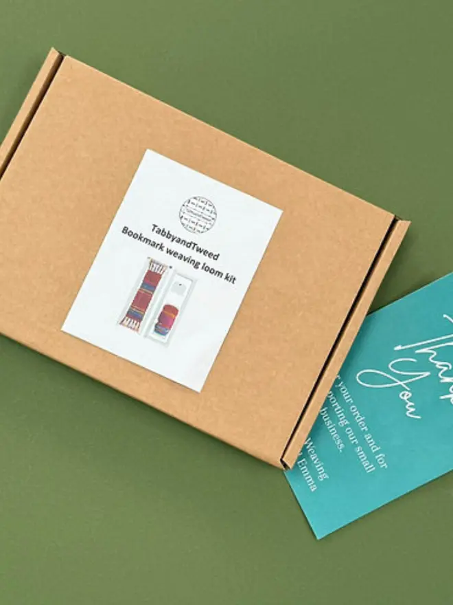 Brown cardboard box next to a thank you card. 