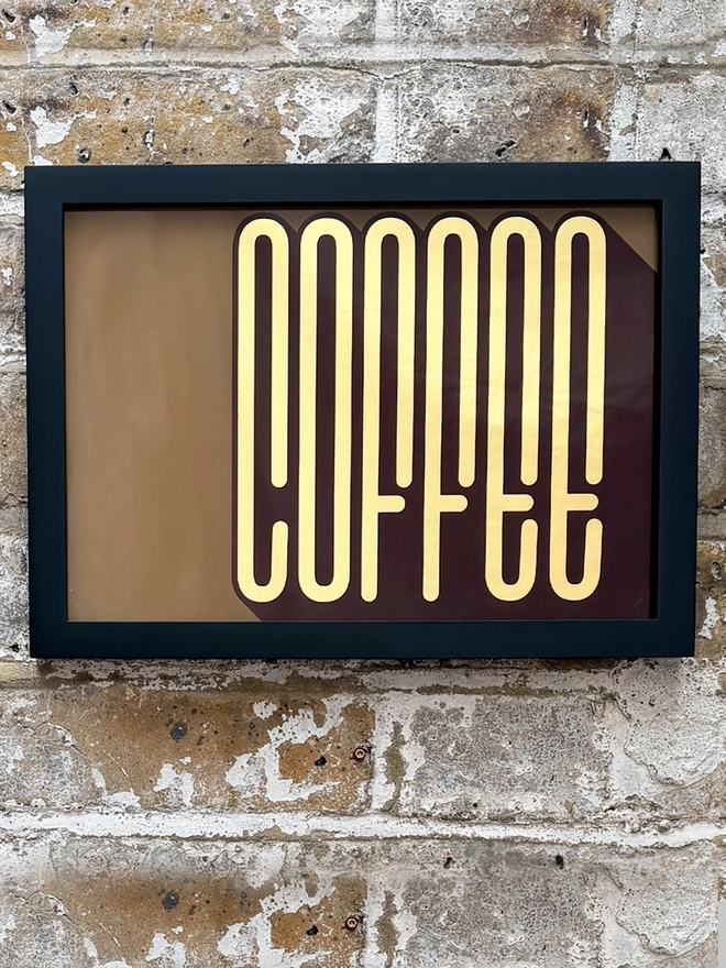 'Coffee' Gold Leaf Glass Artwork, hanging on a brick wall. 