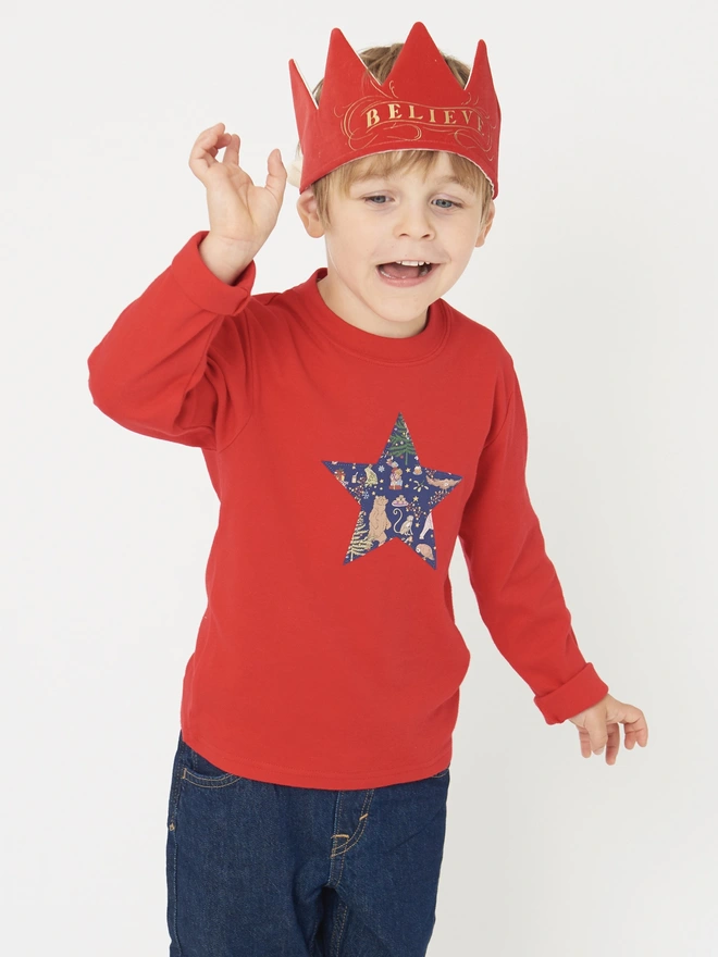 a 4 year old boy wearing a Christmas liberty print star appliquéd on the front