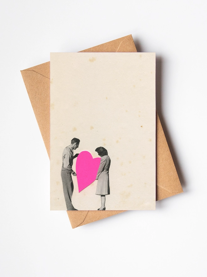 A Valentine's Day greeting card depicting and man and woman holding a large pink love heart.