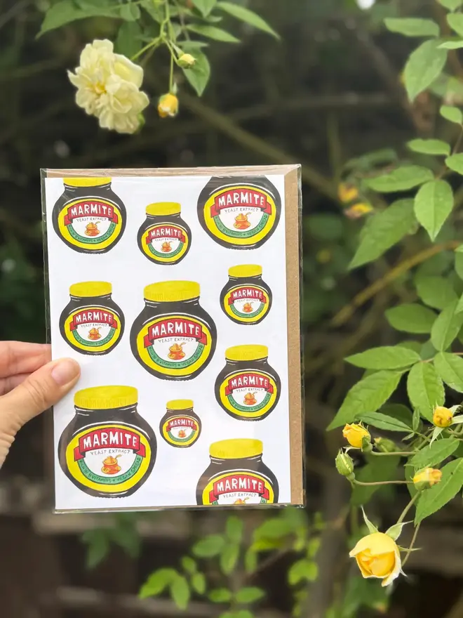 marmite jars illustrated card. card photographed against rosebush backdrop.