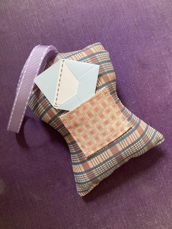 back of a tooth fairy decoration showing a pocket with a small blue envelope sticking out