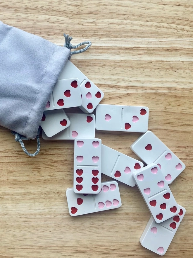 Handmade Valentines And Colourful Jesmonite Dominoes, a group of colourful dominoes on a wooden surface. These have hearts on them. 