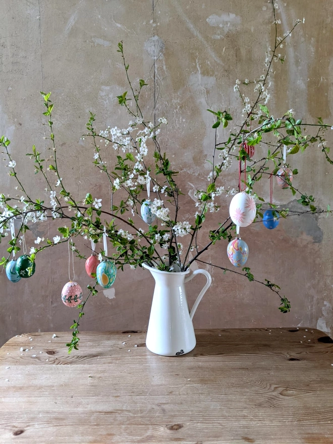 Easter twig in a white jug displaying Easter egg decorations