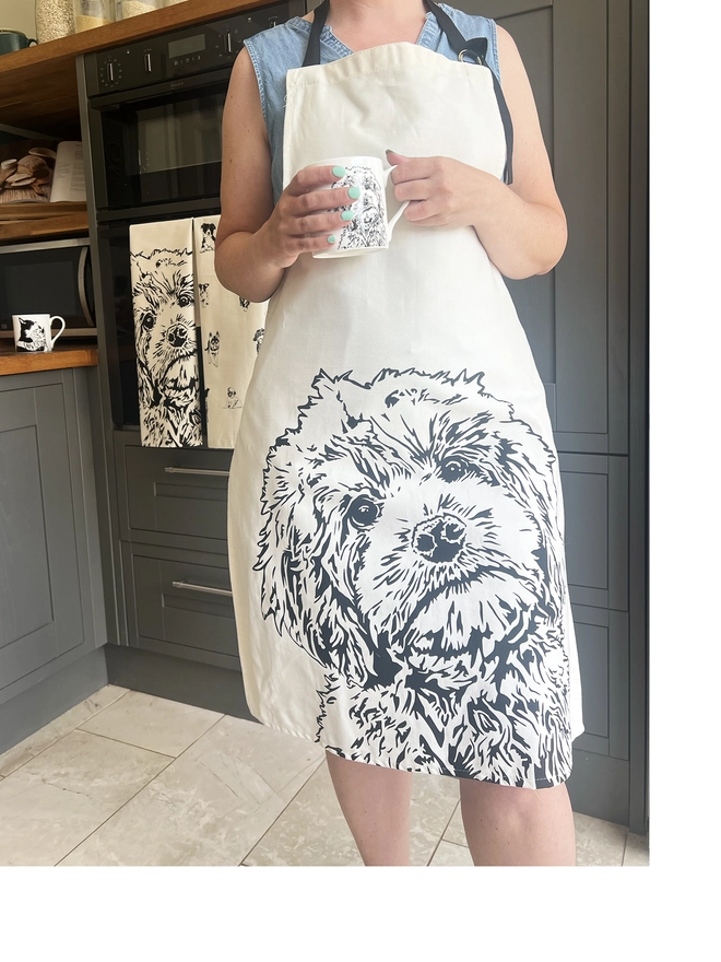Cockapoo apron being worn with a matching cockapoo mug in models hand