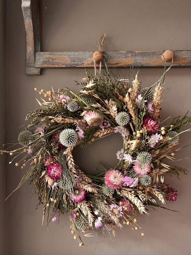 Dried Flower Cottage Wreath. A wreath made of dried flowers, hung up.