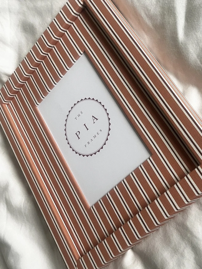 Tangerine & Burgundy Seaside Stripe Frame, a colourful striped frame sitting on a plain white surface. 