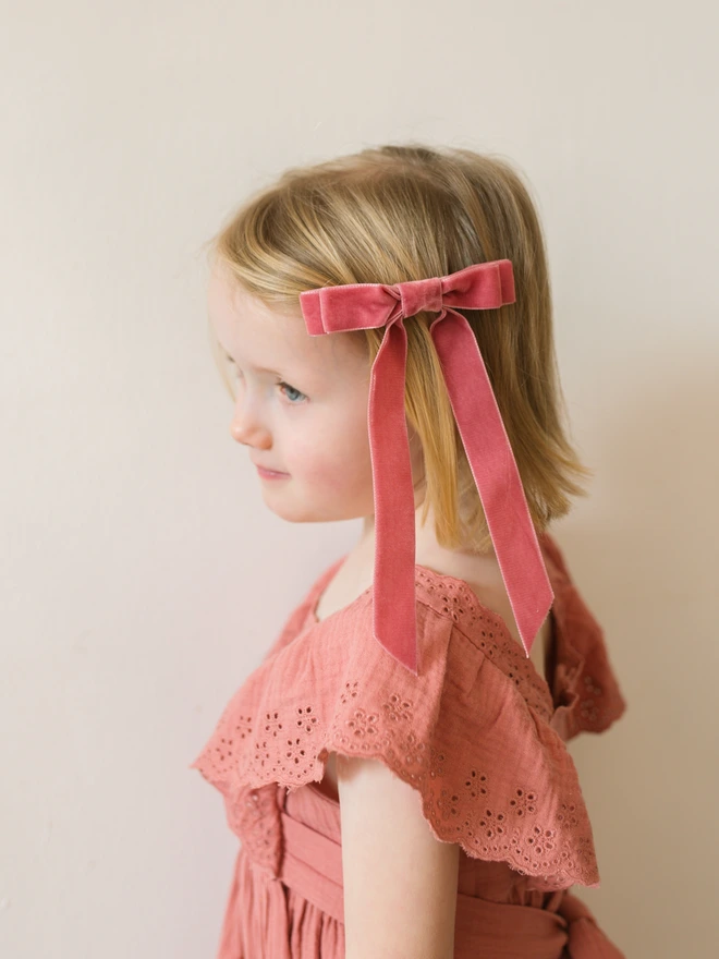 little girls with pink velvet hair bow in her hair 