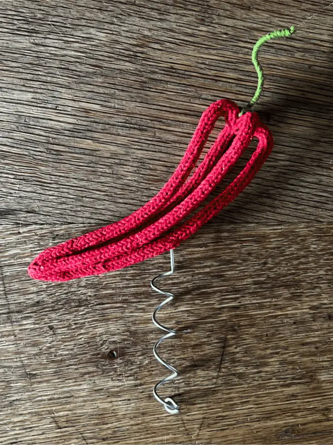 Wire and string chilli tree topper on an oak table