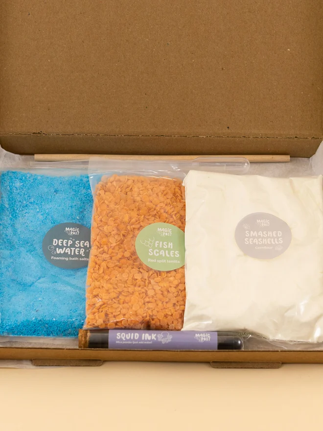 ocean mini sensory potion kit. three bags of assorted sensory materials placed into a cardboard box.