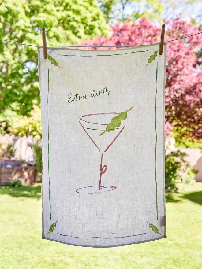 Extra Dirty - Martini Linen Tea Towel, hanging on the washing line in the garden 