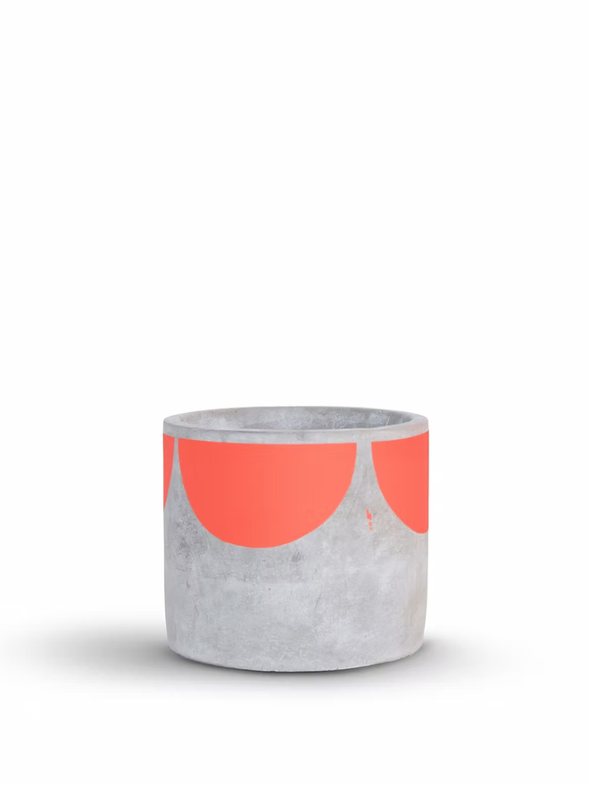 sunny concrete plant pot. a grey plant pot with a coral pink half sun pattern painted around the top rim.