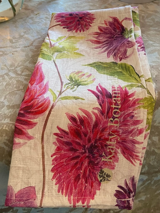 Dahlia Tea Towel. A tea towel patterned with vibrant pink dahlias.