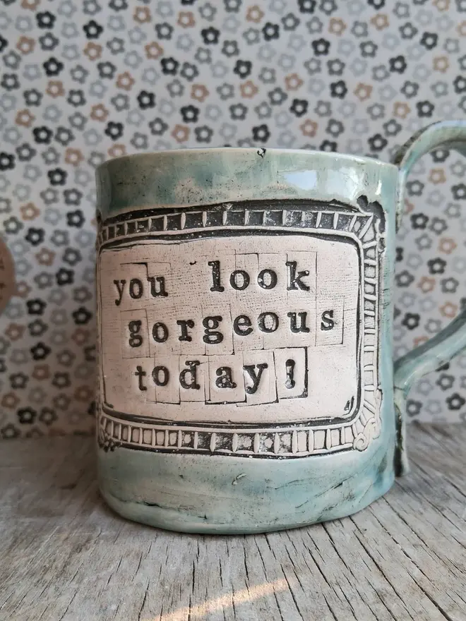 'you look gorgeous today' ceramic mug. a teal blue ceramic mug bearing the slogan 'you look gorgeous today'.