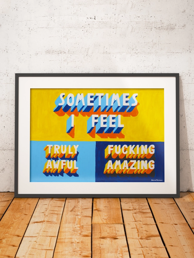Framed typographic art print leaning against a white textured wall on a wooden floor. The artwork features bold 3D-style lettering in blue, yellow and orange with orange and blue shadows on a bright yellow and blues background. The text reads “SOMETIMES I FEEL TRULY AWFUL / FUCKING AM