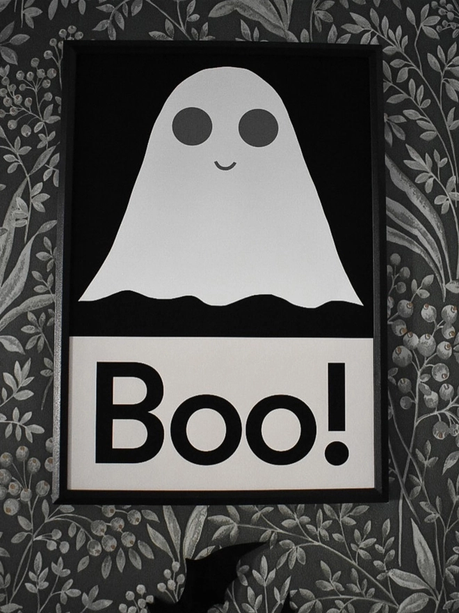 A halloween wall print of a simple white ghost illustration on a black background