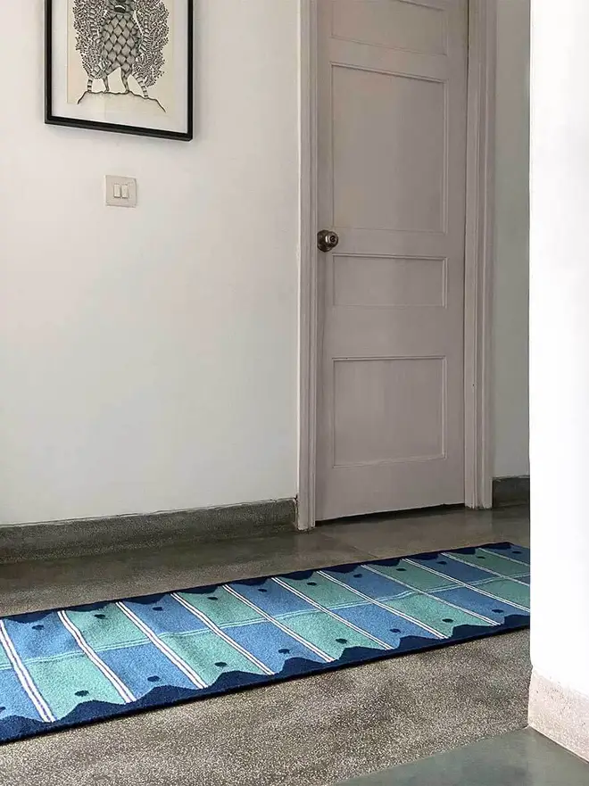 Ladder Flatweave Runner Rug, a colourful rug sitting in a living room. It is accompanied by other household items. 